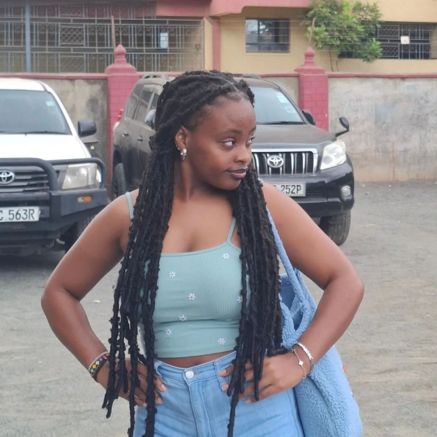 Moreen outdoors, looking thoughtfully to the side